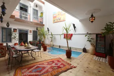 a living room with a table and a potted plant at Riad Capri in Marrakech