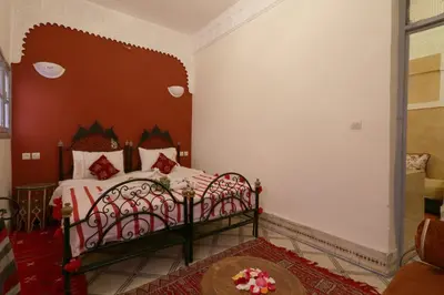 a bedroom with a bed with a red headboard at Riad Capri in Marrakech