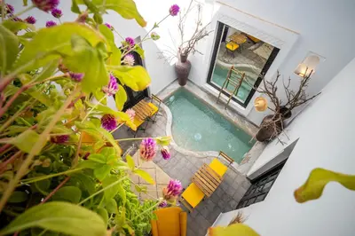 an overhead view of a pool with chairs and flowers at Riad Come & Va Medina in Marrakech