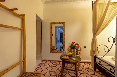 a room with a table and a mirror at Riad des remparts Marrakech in Marrakech