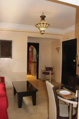 a living room with a red couch and a table at Studio Salmiya Dune in Marrakech