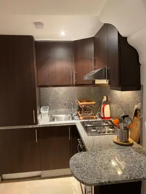 a kitchen with wooden cabinets and a counter top at Studio Salmiya Dune in Marrakech