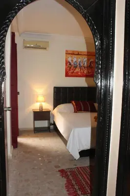 a bedroom with a bed and a table with a lamp at Studio Salmiya Dune in Marrakech