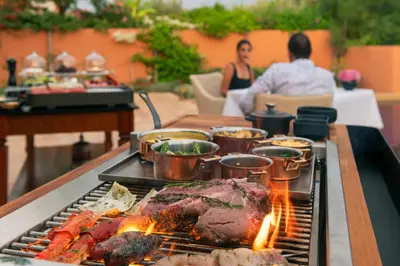a grill with meat and other food on a table at The Oberoi Marrakech in Marrakech