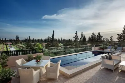 a patio with a table and chairs and a swimming pool at The Oberoi Marrakech in Marrakech