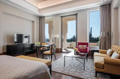 a hotel room with a bed and a living room at The Oberoi Marrakech in Marrakech