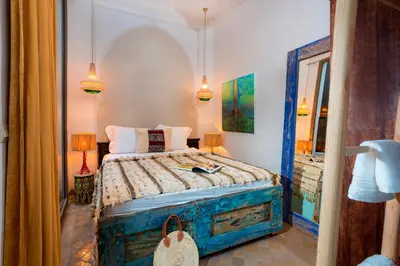 a bedroom with a bed in a room with a window at Riad Lumière in Marrakech