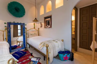 a bedroom with a bed and a mirror at Riad Lumière in Marrakech
