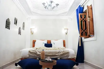 a bedroom with a king sized bed with blue pillows at Riad azra Marrakech in Marrakech