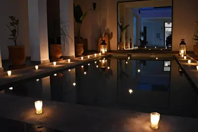 a pool with candles and lights in a room at Riad Dar DARRE in Marrakech