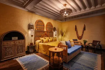 a bedroom with a bed and a couch and a table at Riad Kheirredine in Marrakech