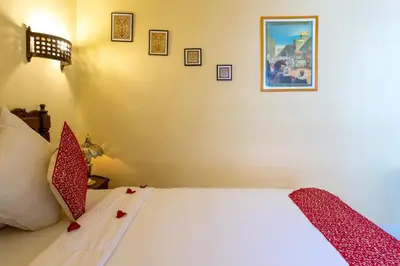 a bedroom with a white bed with red pillows at Riad Al Jana in Marrakech