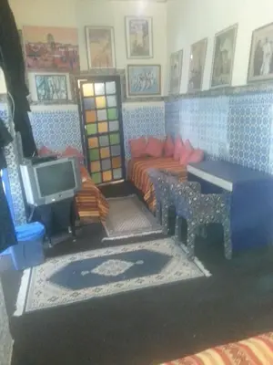 a living room with a bed and a tv at RIAD DAR KADER chambre saumon in Marrakech