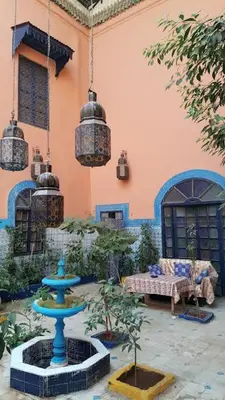 a courtyard with a blue fountain in front of a building at RIAD DAR KADER chambre saumon in Marrakech