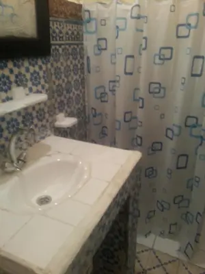 a bathroom with a sink and a shower curtain at RIAD DAR KADER chambre saumon in Marrakech