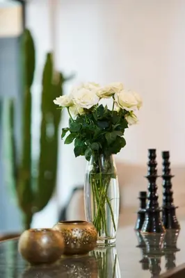 a vase with white roses sitting on top of a table at Riad Miloud en exclusivité 10 P au cœur de la Médina in Marrakech