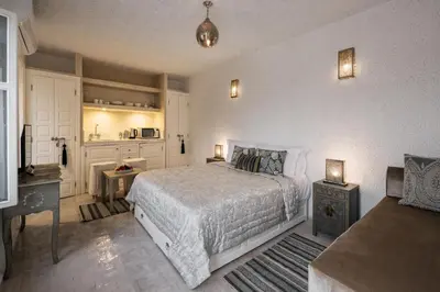 a bedroom with a white bed and a kitchen at Riad Spice by Marrakech Riad in Marrakech