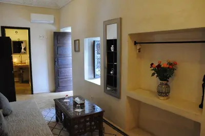 a living room with a vase of flowers on a table at Riad Haraka in Marrakech