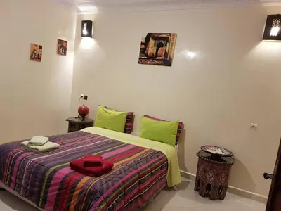 a bedroom with a bed with green pillows at Zwina Appart, A Small, Cozy Family Nest in Marrakech