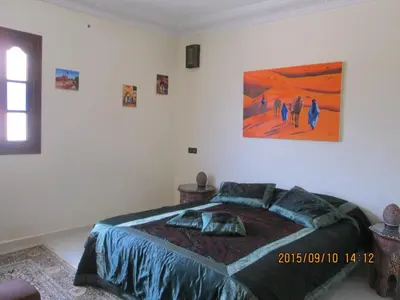 a bedroom with a bed and a painting on the wall at Zwina Appart, A Small, Cozy Family Nest in Marrakech