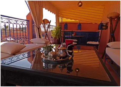 a living room with a table and a balcony at Riad La Rose D'orient in Marrakech