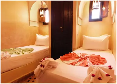 two beds in a room with towels on them at Riad La Rose D'orient in Marrakech