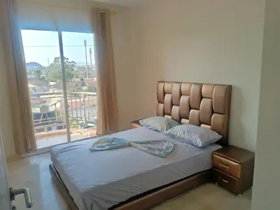 a bedroom with a bed with a large window at Appartement rouge 6 perso in Marrakech