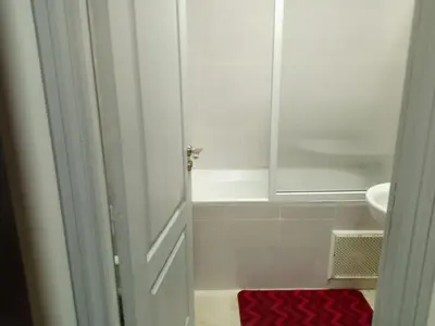 a bathroom with a white tub and a sink at Appartement rouge 6 perso in Marrakech