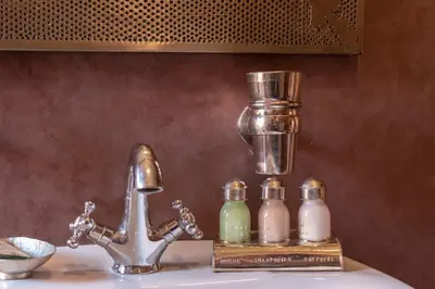 a sink with a faucet and two bottles of soap at Villa Soraya Hammam & Jacuzzi in Marrakech
