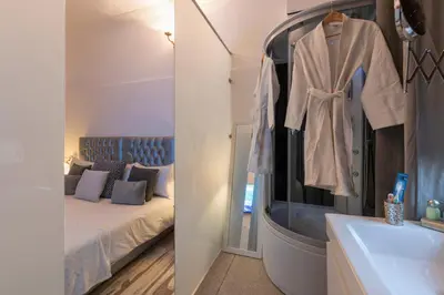 a bedroom with a bed and a sink and a mirror at Villa Soraya Hammam & Jacuzzi in Marrakech