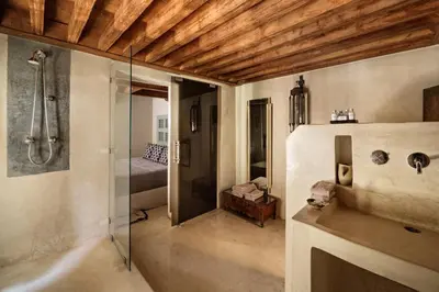 a bathroom with a shower and a bed in a room at Riad 72 in Marrakech
