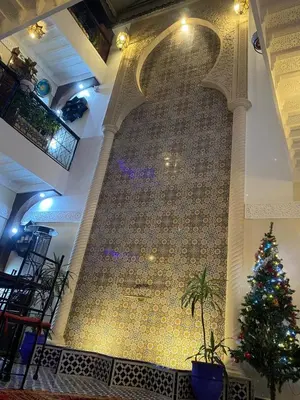 a christmas tree in front of a large wall at Riad Lalla Merieme in Marrakech