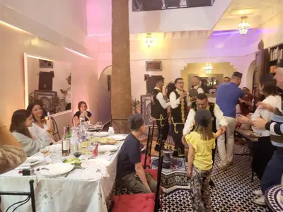 a group of people standing around a table in a room at Riad Lalla Merieme in Marrakech