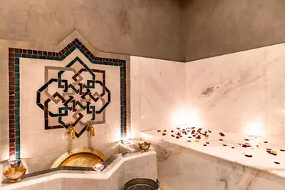 a bathroom with a bath tub and a tile wall at Riad Luciano Hotel and Spa in Marrakech