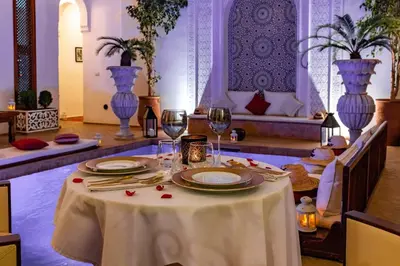 a table with a white table cloth and wine glasses at Riad Luciano Hotel and Spa in Marrakech
