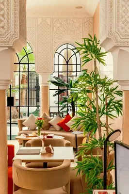 a restaurant with tables and chairs and plants at Riad Luciano Hotel and Spa in Marrakech