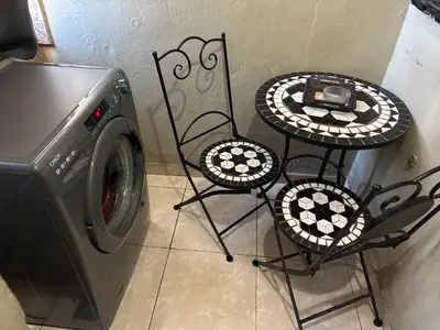 two tables and chairs next to a washing machine at Nice appartement à Marrakech in Marrakech