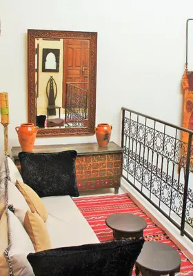 a living room with a couch and a mirror at Riad Alqimam in Marrakech
