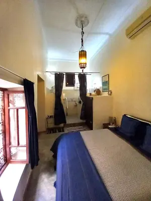 a bedroom with a bed and a room with a bathroom at Riad Alqimam in Marrakech