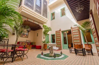 a courtyard with a fountain in the middle of a building at RIAD AZRUR in Marrakech