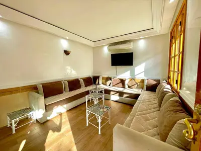 a living room with a couch and a tv at Villa Paradis in Marrakech