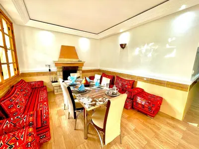 a dining room with a table and chairs and a fireplace at Villa Paradis in Marrakech