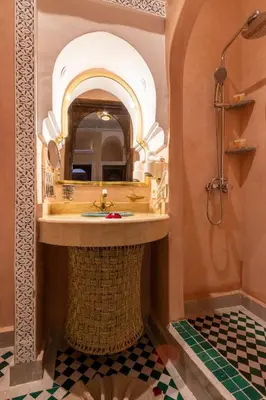 a bathroom with a sink with a mirror at Riad Medina Art & Suites in Marrakech