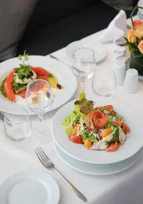 a white table with plates of food and wine glasses at Kenzi Rose Garden in Marrakech