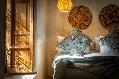 a bedroom with a bed with pillows and a mirror at Medina Sun in Marrakech