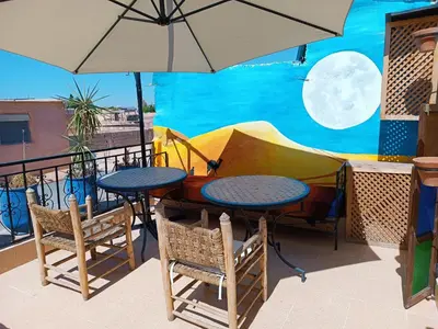 a table and chairs and an umbrella on a balcony at Terrace House in Marrakech