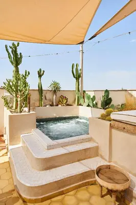a swimming pool with cacti on a patio at Riad Dar Yasaman in Marrakech