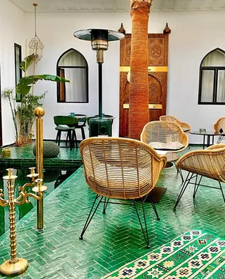 a room with rattan chairs and a glass table at Riad Dar Yasaman in Marrakech