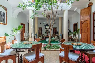 a living room with two tables and a pool at Riad Dar Kasal in Marrakech