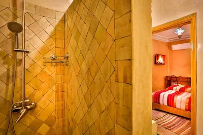 a bathroom with a shower and a bedroom at RIAD VILLA SIDI BABA in Marrakech